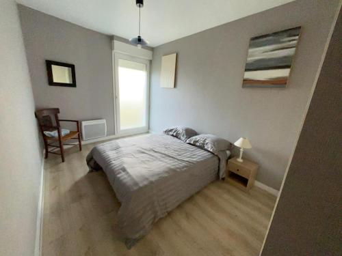 une chambre avec un grand lit et une fenêtre dans l'établissement Appartement en centre ville avec cour face au parc pasteur, à Orléans