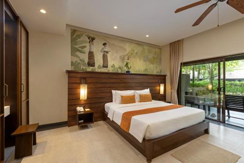 a bedroom with a bed and a painting on the wall at Khaolak Wanaburee Resort - SHA Extra Plus in Khao Lak