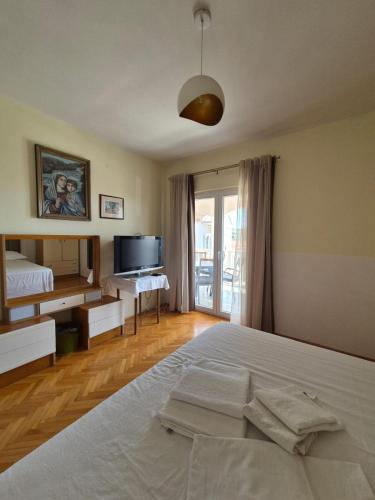 a bedroom with a large bed and a television at Apartmani Zora in Primošten