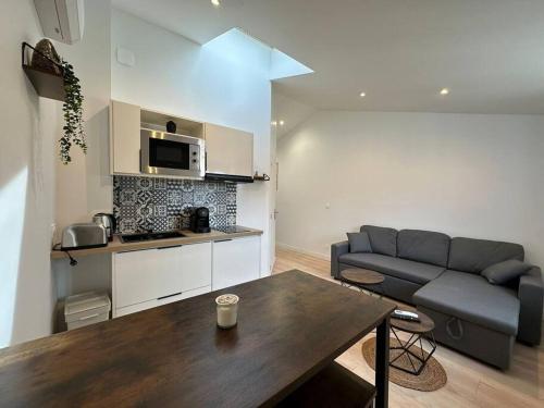 un salon avec un canapé et une table dans l'établissement Malaga, appartement cosy et convivial, à Reims