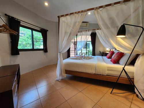 a bedroom with a bed with a canopy at Soleil D'asie Residence in Chaweng Noi Beach