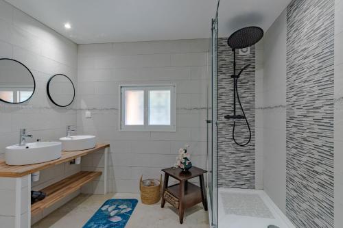 Un baño con dos lavabos y una ducha. en La Villa du Mas des Chenes, en Pomport