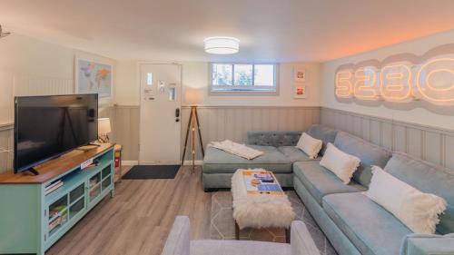 a living room with a couch and a flat screen tv at Sloans Lake Walk to eateries bars Free parking in Denver