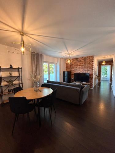 un salon avec un canapé et une table dans l'établissement BoleslaviaApartments - Apartament Arte 4, parking free, EV, à Bolesławiec