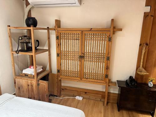 a bedroom with a bed and a wooden partition at Arirang Hanok Stay in Daegu