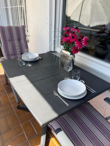 a table with plates and glasses and flowers on it at Ferienwohnung Flynn in Sonthofen