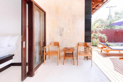 a room with chairs and a table on a patio at Villa Kamaria in Gili Air