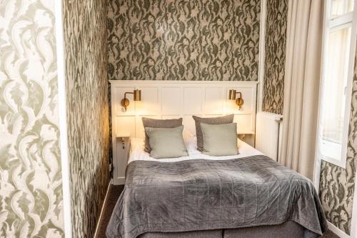 a bedroom with a bed in a room with wallpaper at Mössebergs Kurort in Falköping