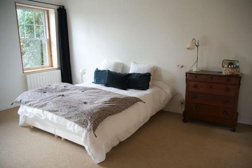 une chambre avec un lit, une commode et une fenêtre dans l'établissement Séjour paisible maison de charme, à Gueutteville-les-Grès