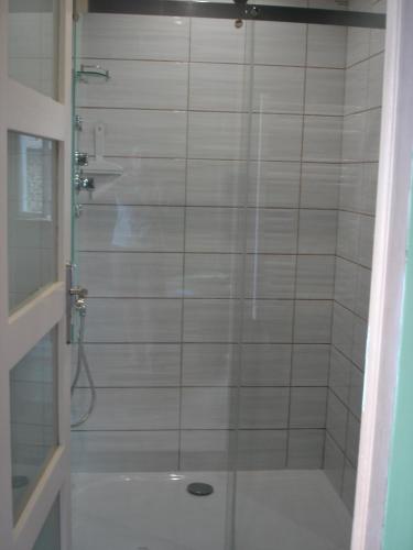 une douche avec une porte vitrée dans une salle de bain dans l'établissement Maison Balette, à Escou