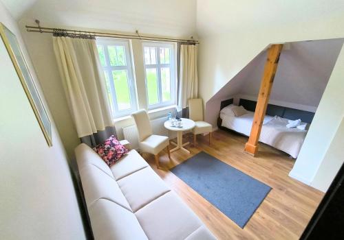 a living room with a white couch and a bed at Villa Lessing in Polanica-Zdrój