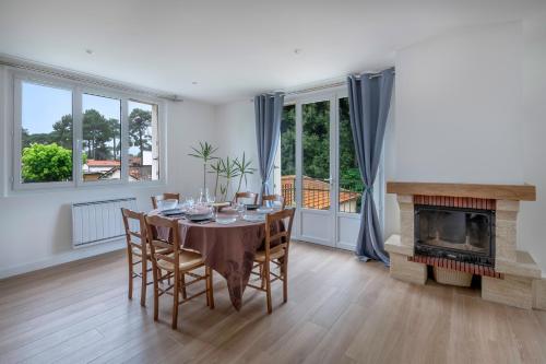 une salle à manger avec une table et une cheminée dans l'établissement Maison et jardin, 600m de la mer, St Brevin, à Saint-Brévin-les-Pins