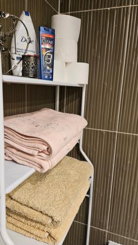a shelf with towels and toiletries in a bathroom at Apartman Al Dora Resindence in Hurghada