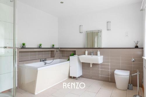 a bathroom with a tub and a sink and a toilet at Vibrant 2-bed Home in Nottingham by Renzo, Free Driveway Parking, Sleeps 6! in Nottingham