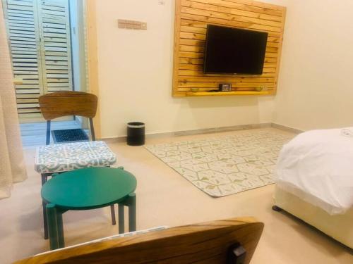 a bedroom with a bed and a television on a wall at Beach Chalet - 9 in Al Ḩadd