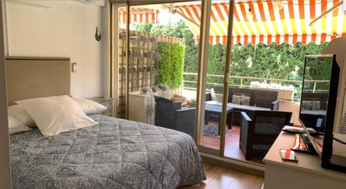 - une chambre avec un lit et une vue sur une terrasse dans l'établissement Appartement 4 p avec grande terrasse, piscine, parking dans Saint Tropez centre, à Saint-Tropez