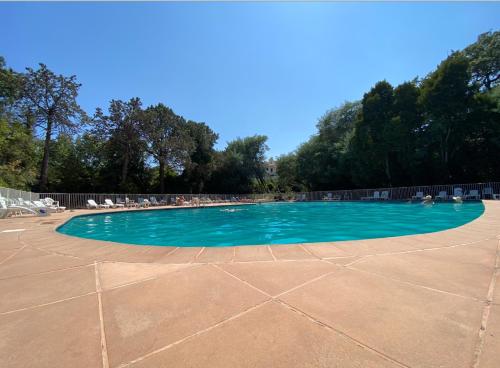 - une piscine d'eau bleue dans un parc dans l'établissement Appartement 4 p avec grande terrasse, piscine, parking dans Saint Tropez centre, à Saint-Tropez