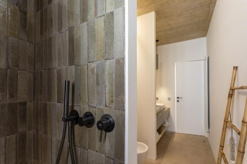 ein Badezimmer mit einer Steinwand in der Unterkunft Villa Calamare - IsulaTravel in Avola