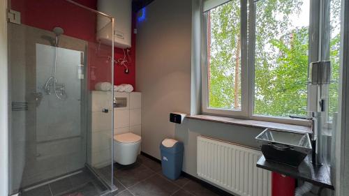 a bathroom with a shower and a toilet and a window at Fire Station Hostel in Lviv