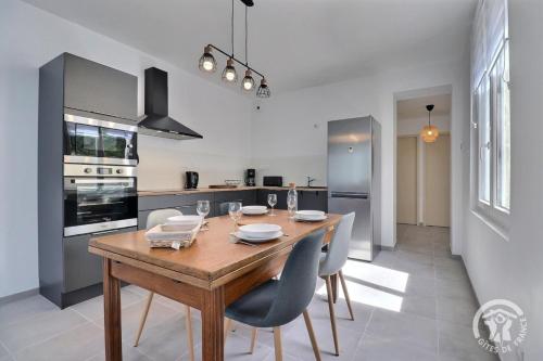 une cuisine avec une table en bois et quelques chaises dans l'établissement La baleine, à Liffré