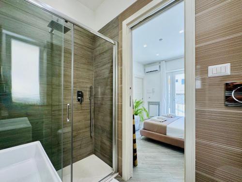 a bathroom with a glass shower and a bed at YourHome - Santa Lucia Rooms in Sorrento