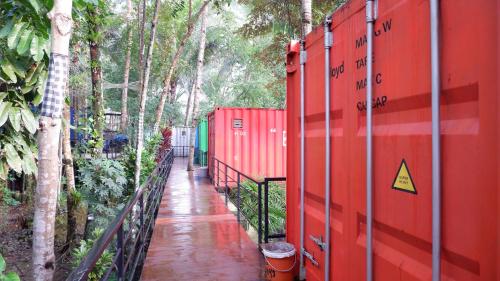 a red fence next to a sidewalk with trees at Hau Eco Lodges Citumang Pangandaran in Pangandaran