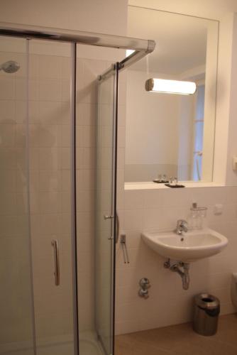 a bathroom with a glass shower and a sink at Norling Guest House in Vienna
