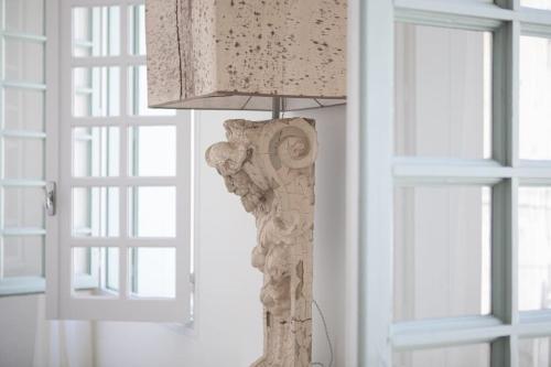 a lamp in a room next to two windows at Les Atlantes in Uzès