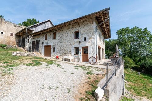 une ancienne maison en pierre avec une clôture devant elle dans l'établissement Les Bellevues, à Moye