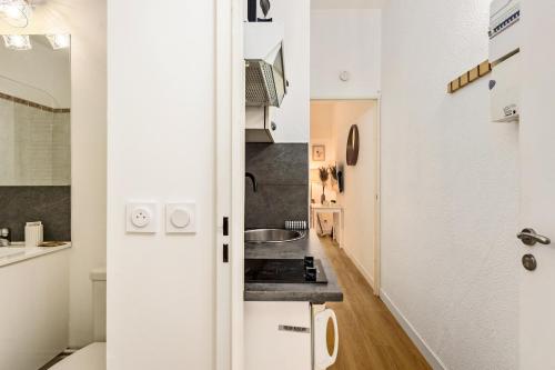 une petite cuisine avec des armoires blanches et une cuisinière dans l'établissement Medicis, à Beausoleil