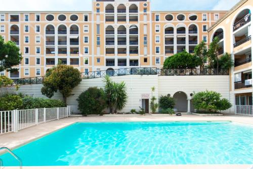 une piscine devant un immeuble dans l'établissement Medicis, à Beausoleil