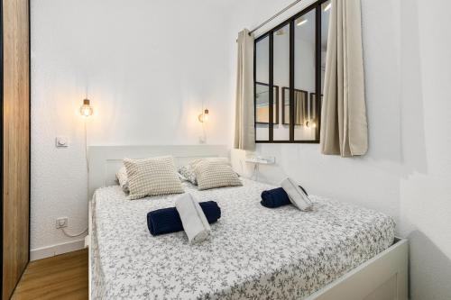 - une chambre blanche avec un lit et des oreillers bleus dans l'établissement Medicis, à Beausoleil