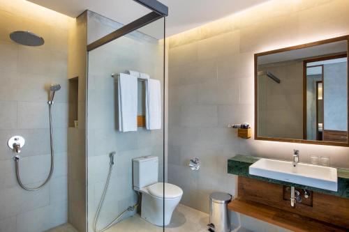 a bathroom with a toilet and a sink and a shower at Greenhost Boutique Hotel Prawirotaman in Yogyakarta