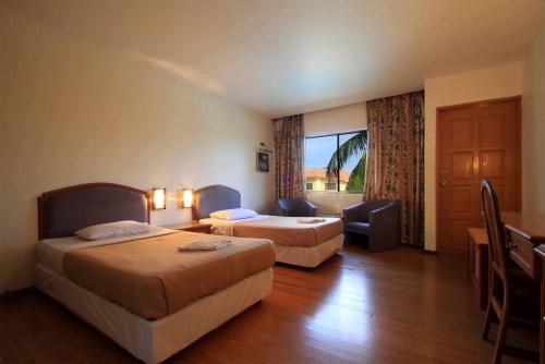 ein Hotelzimmer mit zwei Betten und einem Fenster in der Unterkunft Seri Indah Resort in Kuala Terengganu