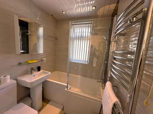 a bathroom with a sink and a toilet and a shower at Luxurious House in Luton with free parking in Luton