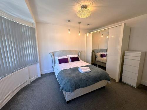 a bedroom with a bed and a large mirror at Luxurious House in Luton with free parking in Luton