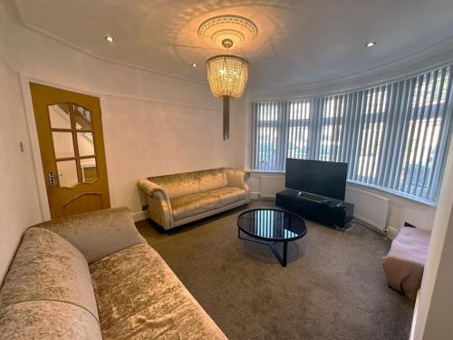 a living room with a couch and a table at Luxurious House in Luton with free parking in Luton
