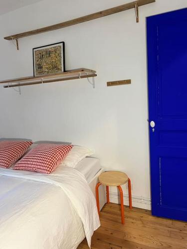 une chambre avec un lit avec une porte bleue et un tabouret dans l'établissement Chambre proche Stade de France, métro à 5min, à Saint-Denis
