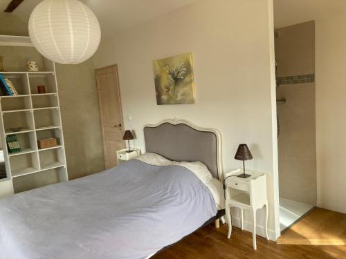 - une chambre avec un lit blanc et 2 tables de chevet dans l'établissement L'Amandière, à Crest