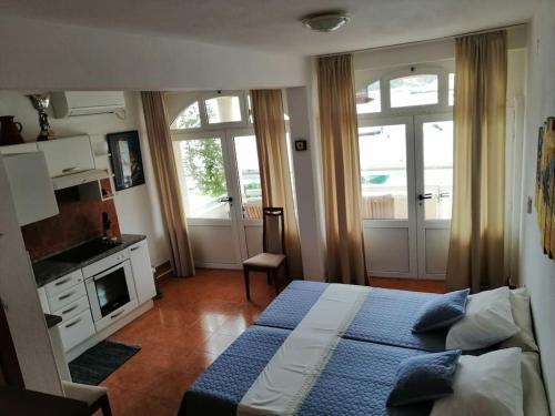 a bedroom with a bed and a fireplace and windows at Studio apartment Milna, Hvar Buratovic in Hvar