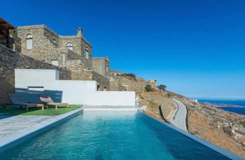 a swimming pool in front of a building at Villa Cybele Tinos in Kardiani