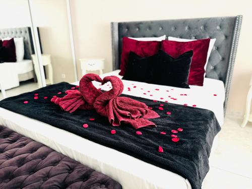 - un lit avec une couverture noire et des oreillers rouges dans l'établissement Escapade Méditerranéenne, à Cagnes-sur-Mer