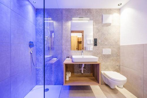 ein Badezimmer mit Waschbecken, Toilette und Dusche in der Unterkunft Schmalzlhof Hotel & Apartments in Oberrasen