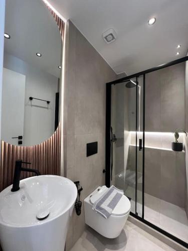 a bathroom with a sink and a toilet and a shower at BlueMotion - PortSuite 5A in Piraeus