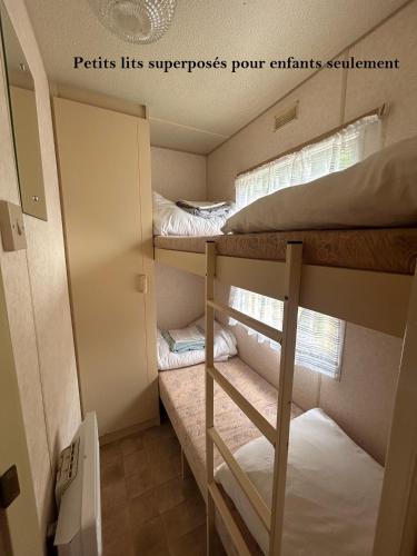 une petite pièce avec deux lits superposés dans l'établissement Mobil-home Vintage au bord de la rivière, à Tardets-Sorholus