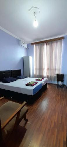 a bedroom with a large bed and a wooden floor at Guesthouse Qeti in Batumi