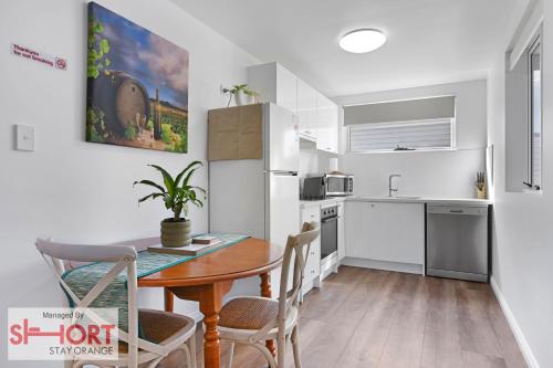 a kitchen with a wooden table and a dining room at Conservatorium Villa 1 in Orange