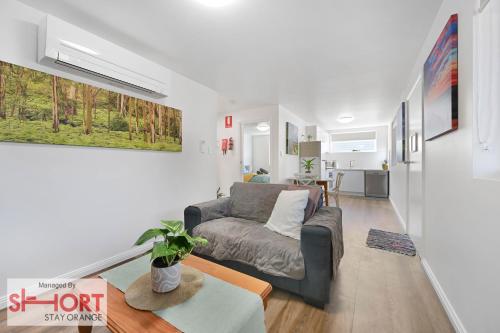 a living room with a couch and a table at Conservatorium Villa 1 in Orange