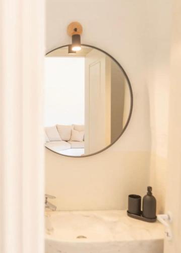 a bathroom with a mirror over a sink at Villa Cybele Tinos in Kardhianí