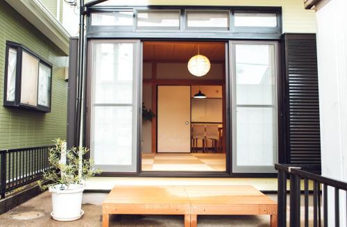 a porch with a wooden table and a bench at Blessing Guest House in Funabashi